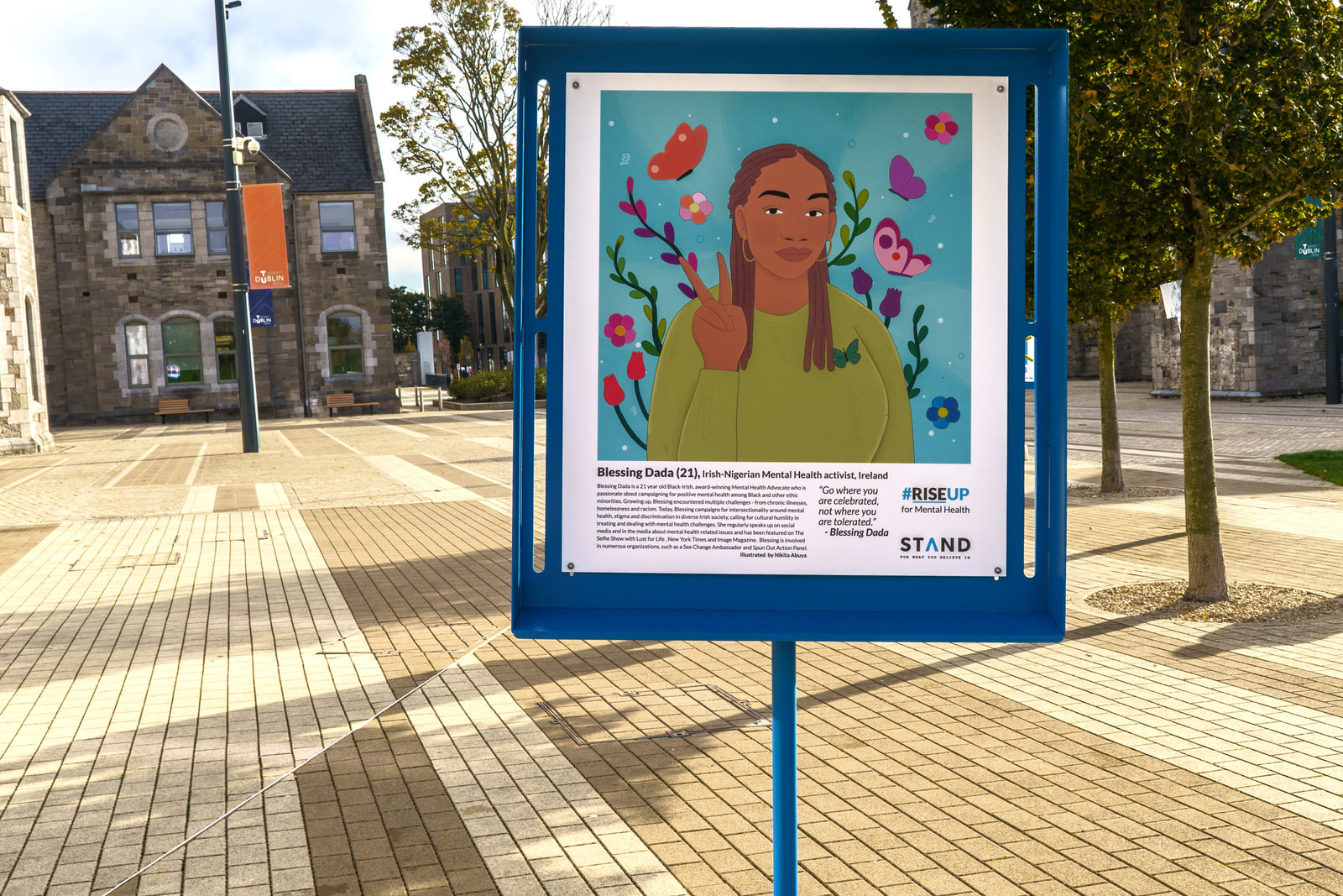 STAND festival sign with graphic painting of a girl on a blue background outdoors at TU Dublin campus