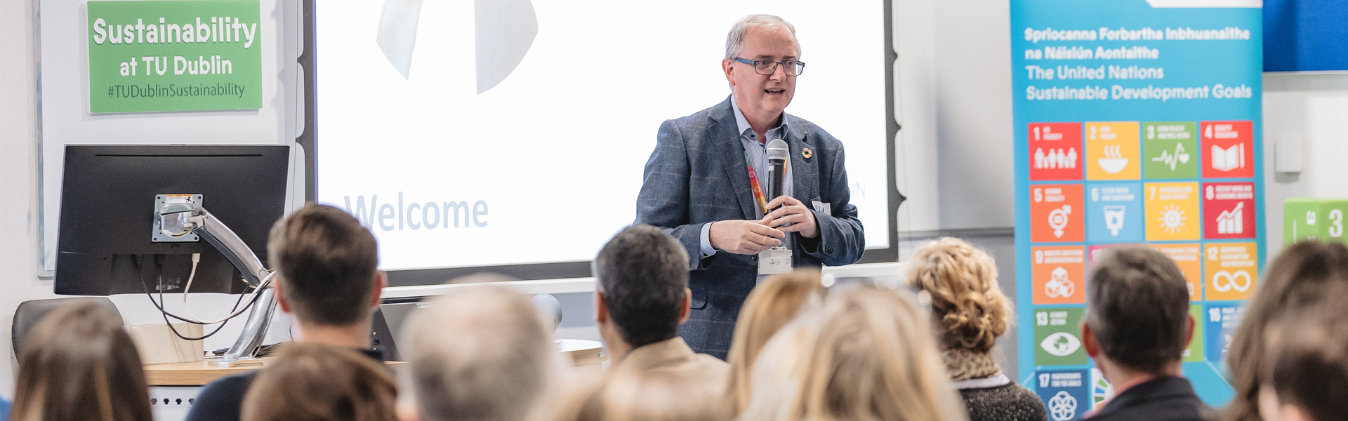 man with microphone giving a talk to an audience