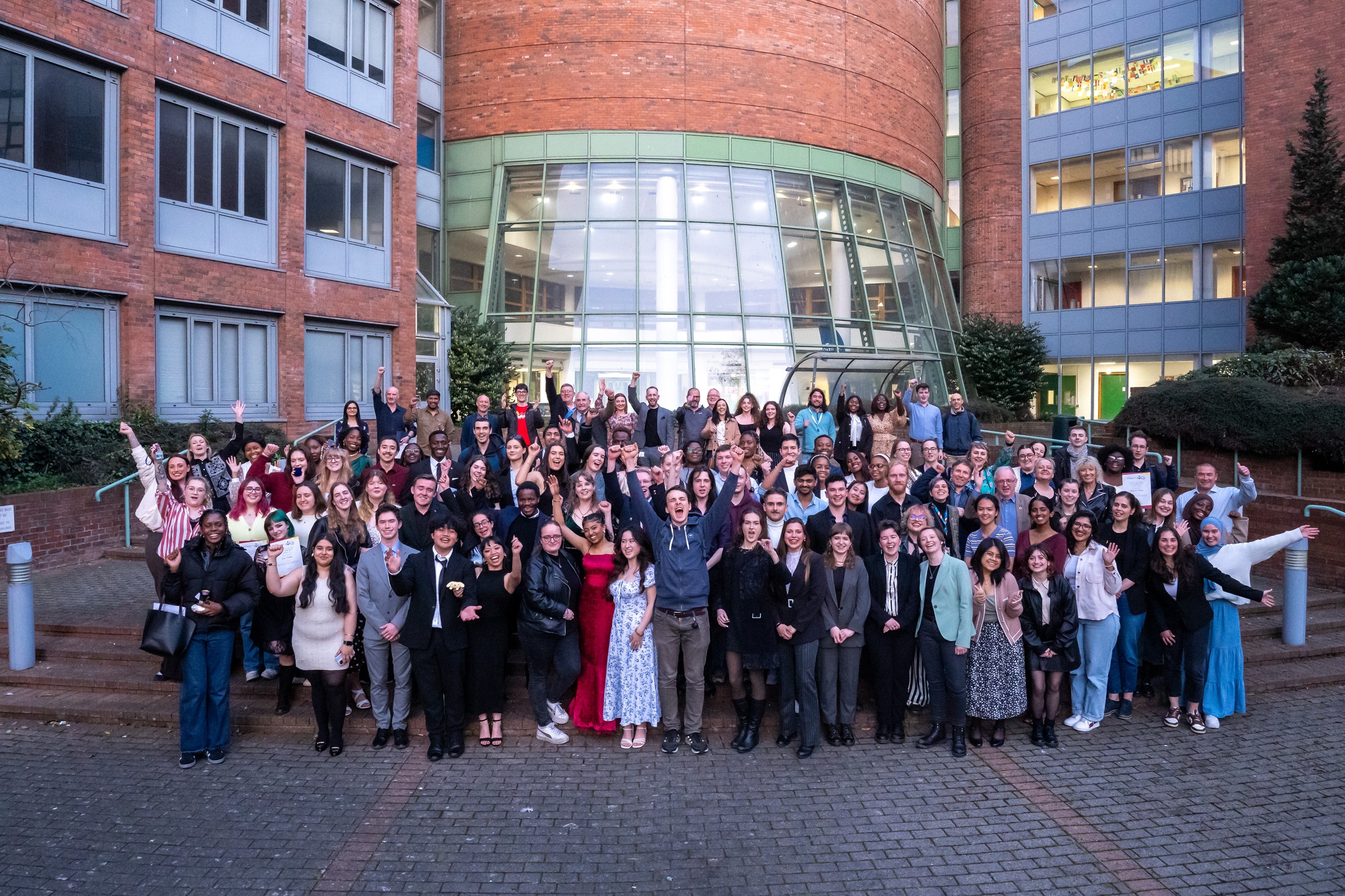A group of students standing in rows celebrating their award wins.