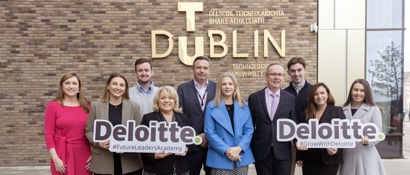 Deloitte representatives holding Deloitte sign