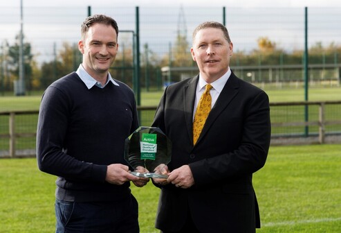 An image of Derrick Crowley (Sport Facility Coordinator), and John Doran (President) holding an award