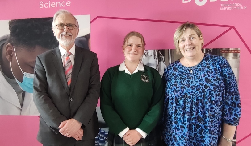 People smiling in front of a banner