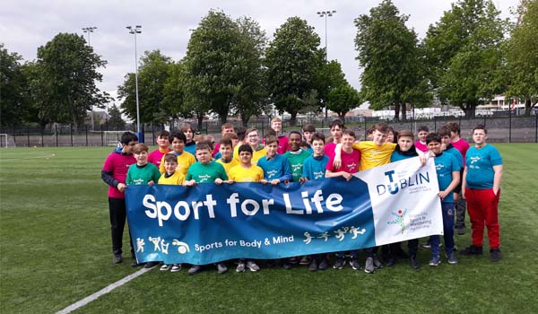 Young students standing behind a banner that says Sport for Life